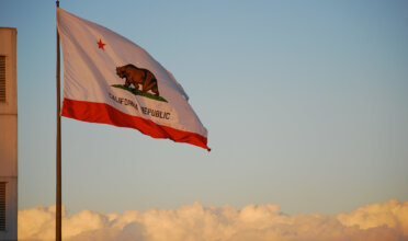 California state flag flies over the clouds